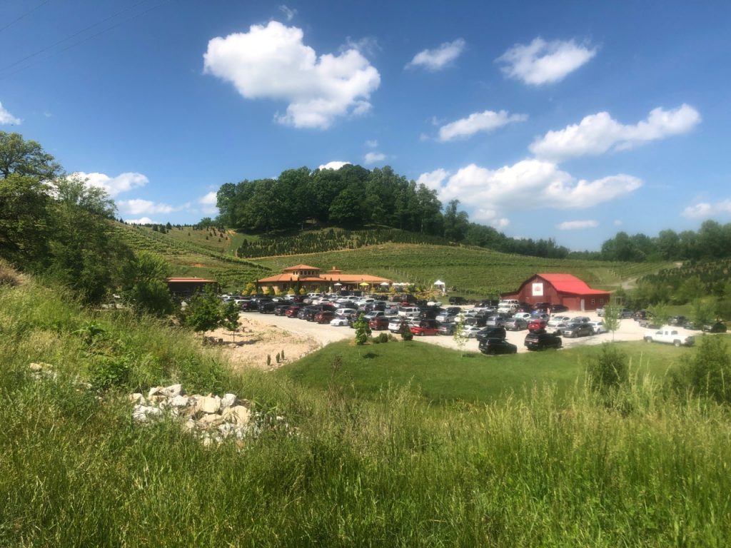 Linville Falls Winery in the distance with many cars in the parking lot on a nice summer day.