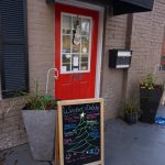 marketing sign in front of a red door