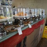 pastries sitting in cake plates on a bar