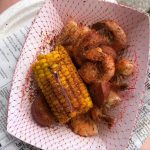 shrimp, corn, potatoes, and sausage in a paper tray
