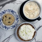 A cookie, coffee, and key lime pie against a marble background.
