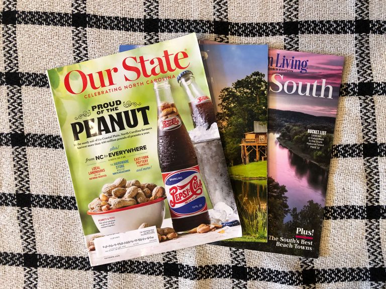 Three outdoor magazines on a picnic tablecloth