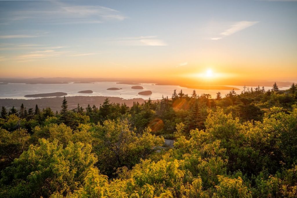 sunrise over the ocean beyond the treeline in one of the best East Coast National Parks