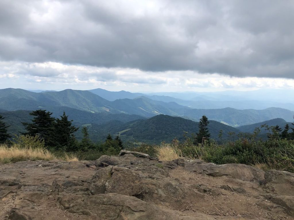Rocky mountain top with layers of mountains showing up in the distance offering some of the best hiking in Johnson City, TN.