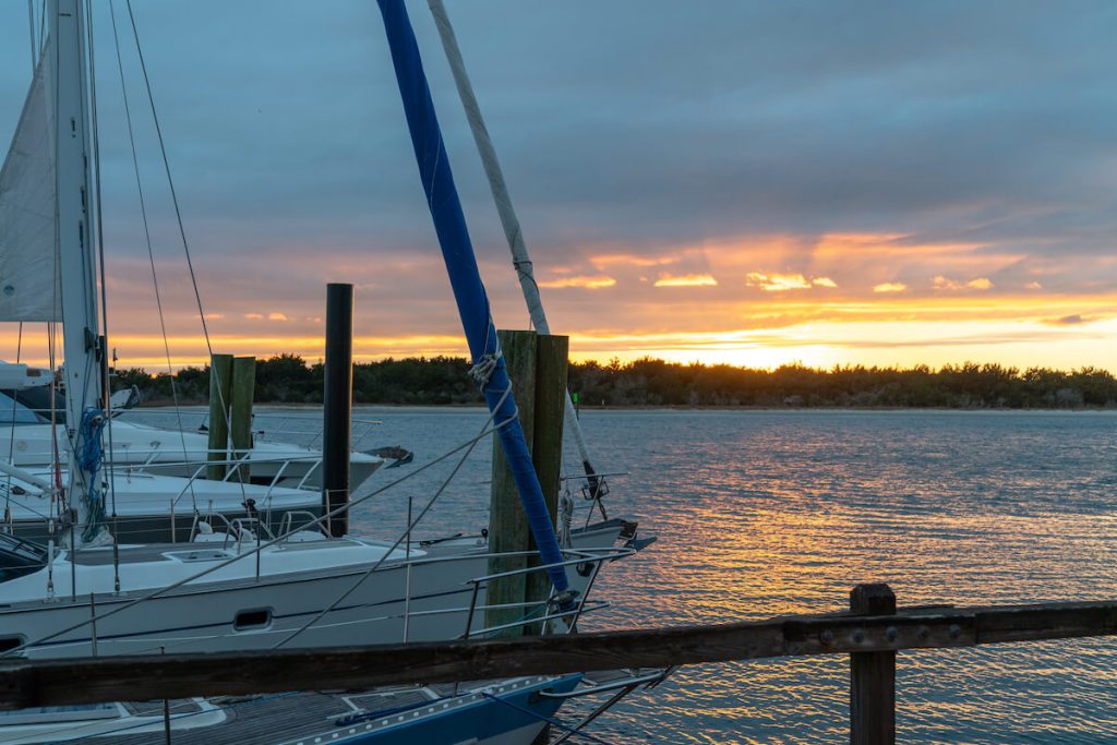sunset across the creek with boats in the marina