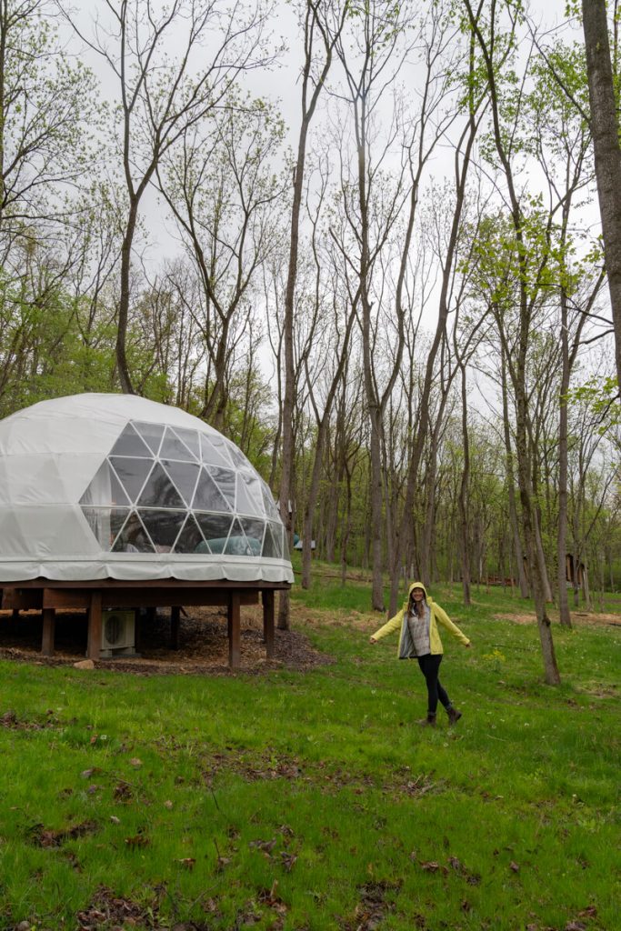 girl twirling in front of glamping dome