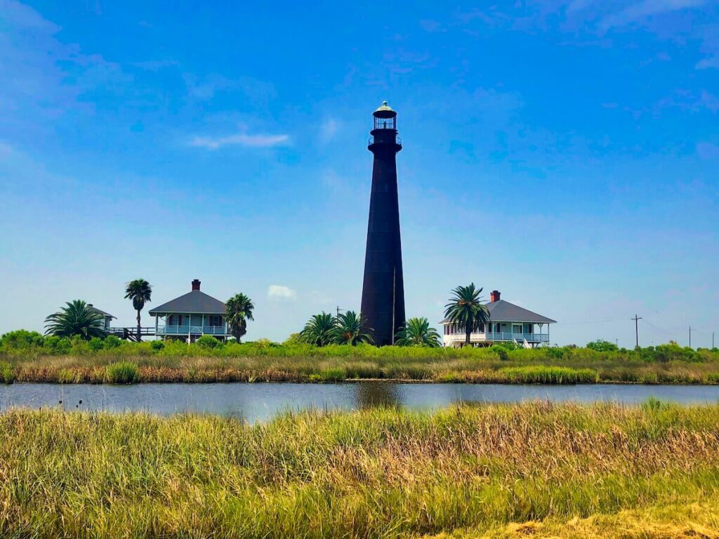 Lighthouse with two houses beside it across the sound.