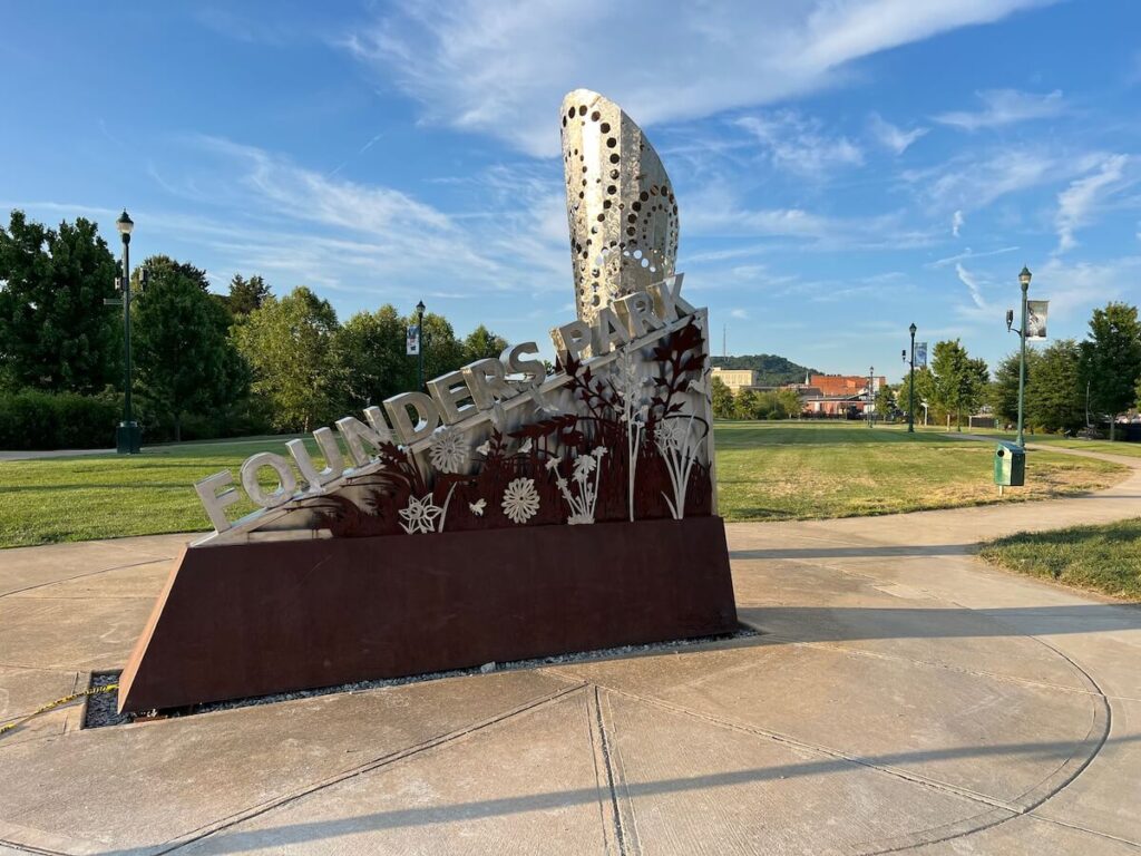 Founders Park sign with sculpture in the background.