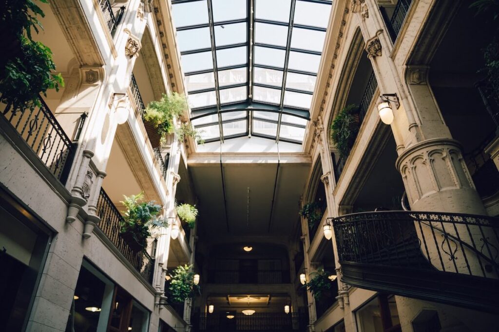 Interior of building with beautiful architectural details, large skylight, and circular iron staircase.