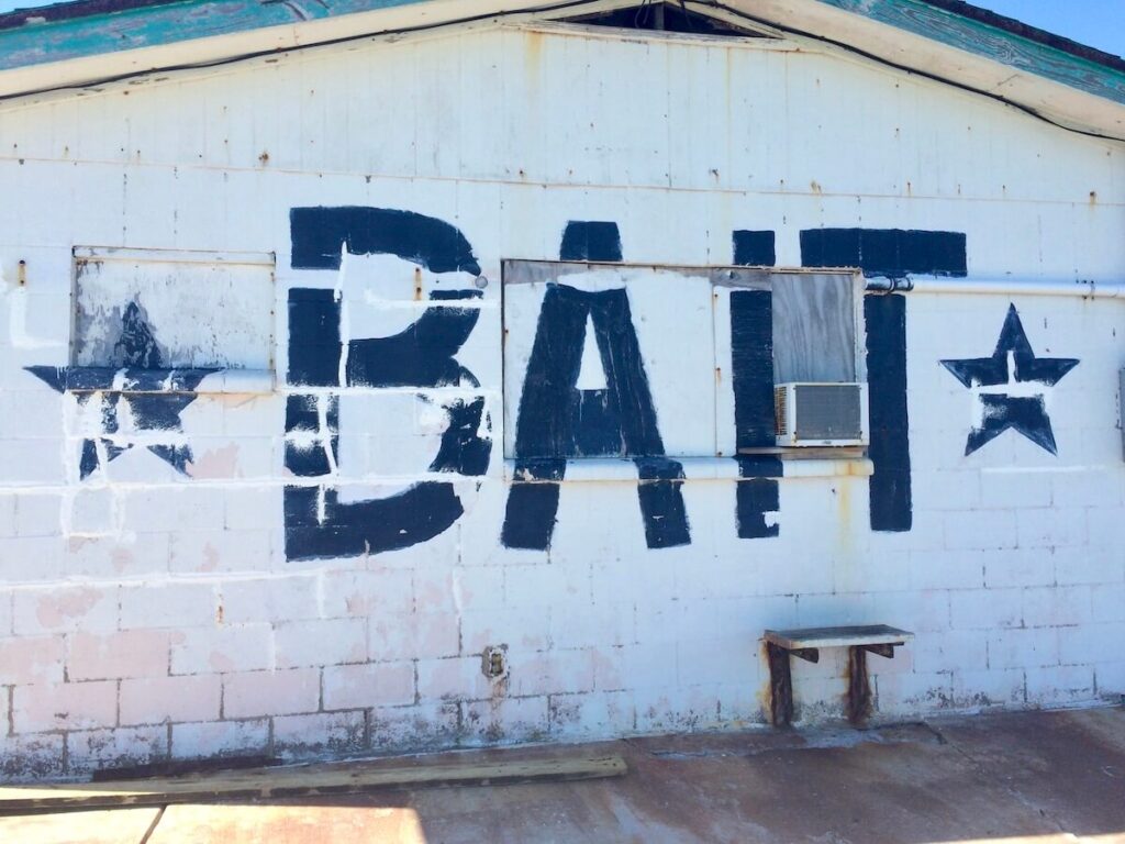 End of building painted with the word "Bait" at one of the best beaches near Houston.