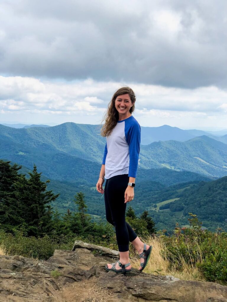Woman standing in front of mountain view after some of the best hiking near Johnson City, TN.