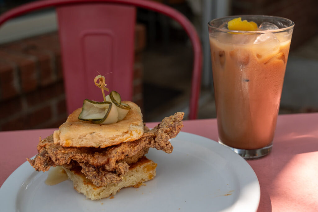 Chicken & biscuit with coffee drink on a table. This is one of the best breakfasts in Asheville.
