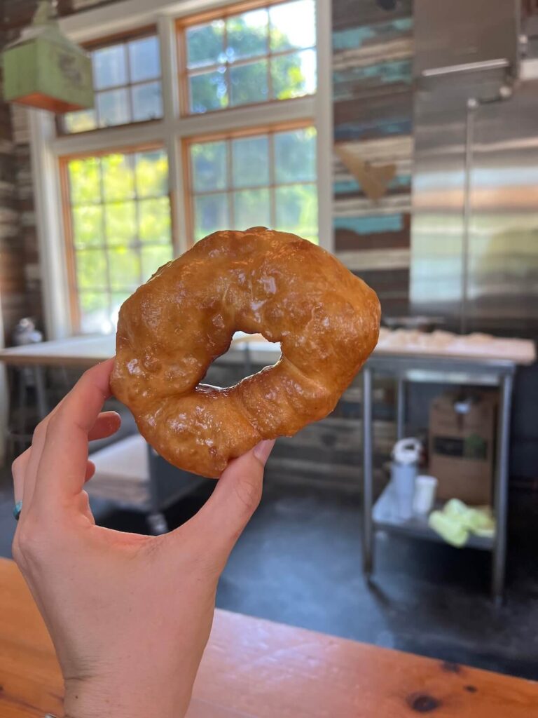 Hand holding a golden-brown donut.