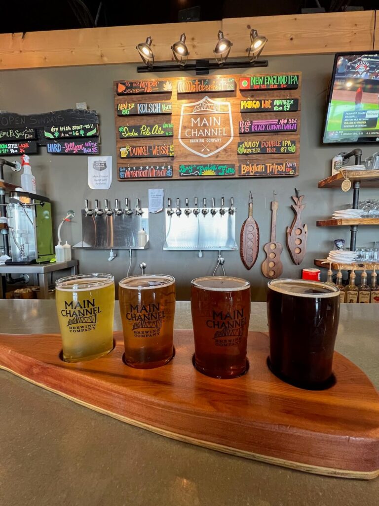 Beer flight in front of taps and beer menu.