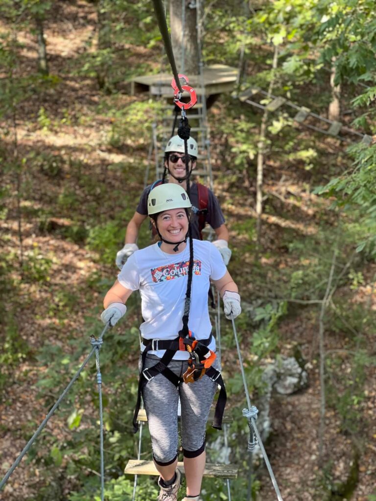 Man and woman crossing a sky bridge while ziplining which is one of the best things to do in Guntersville, AL.