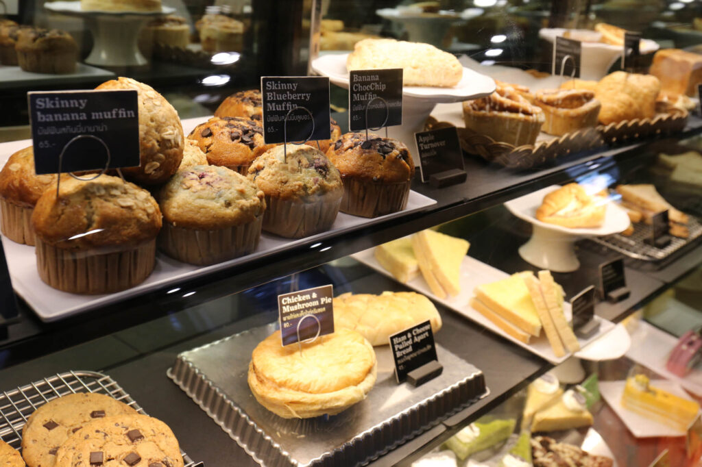 Pastry counter with muffins, cookies, and desserts.