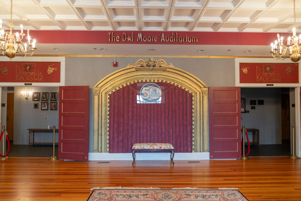 Auditorium entrance with large doors and chandeliers.