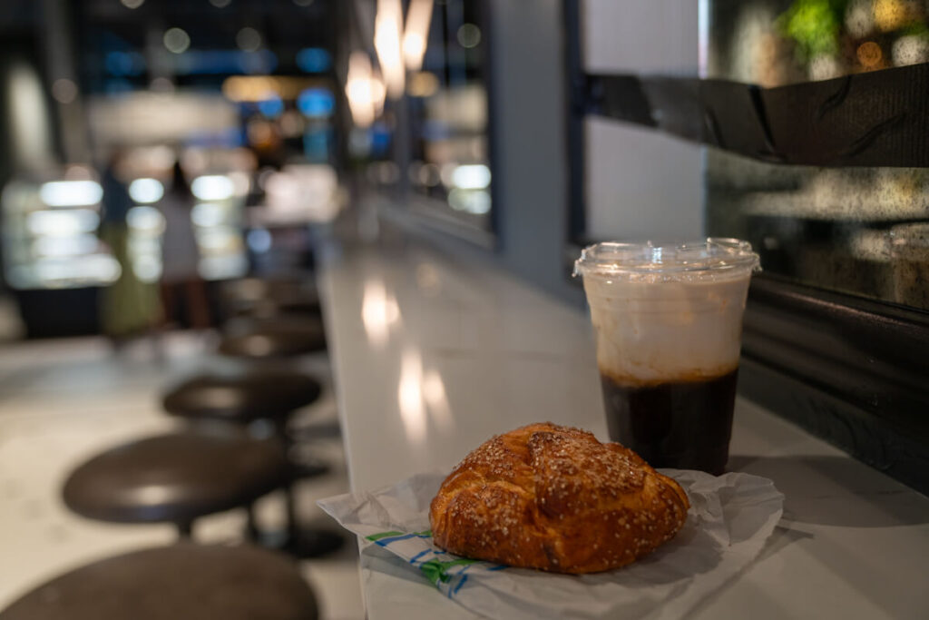 Pastry and cold brew sitting on counter inside Asheville coffee shop.
