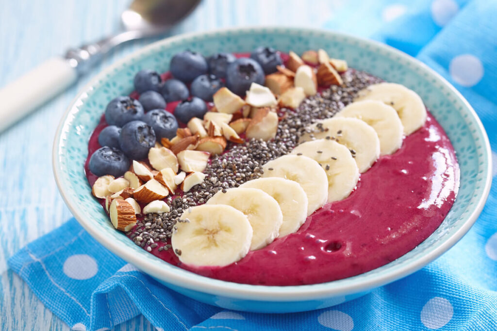 smoothie bowl with bananas, nuts, and berries