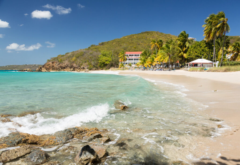 Rocky St. Thomas beach with resort in the background.