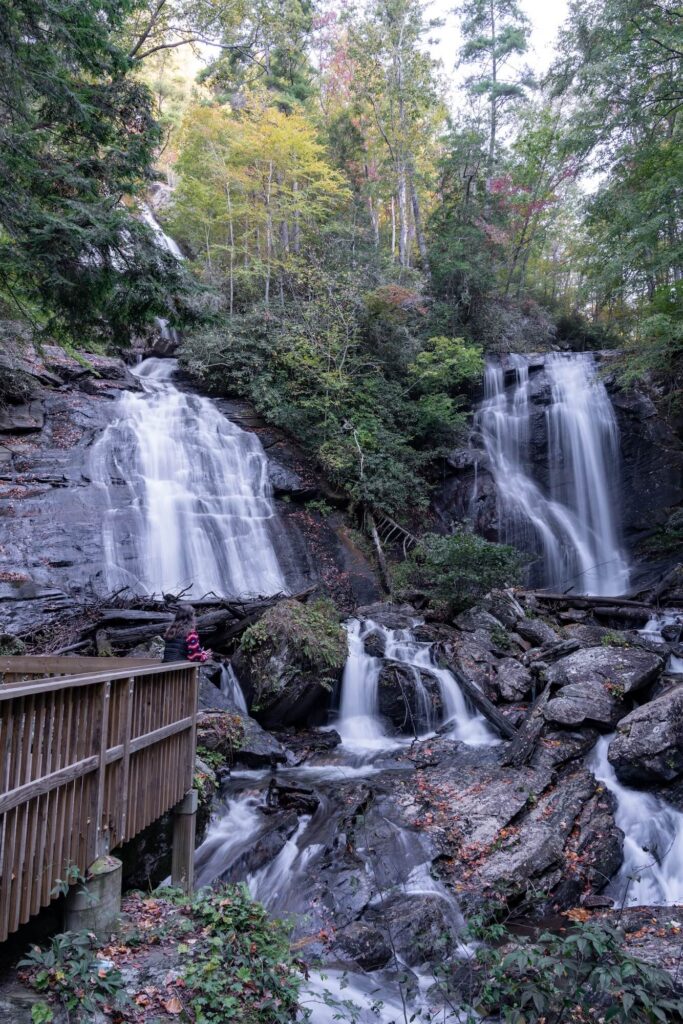 Dual waterfalls with girl standing on viewing platform in front