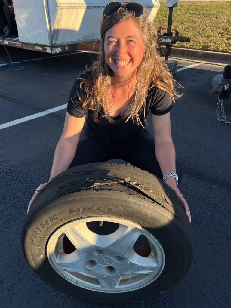girl holding tire that is completely bald and fraying