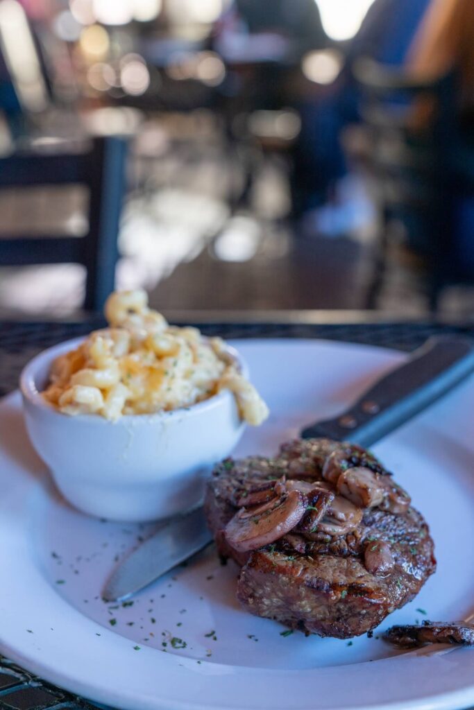 steak topped with mushrooms and mac & cheese