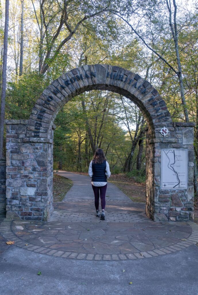 stone arch reading "Helen to Hardman Heritage Trail" with girl below